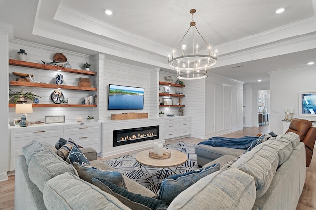 24 Palmer Ln, Santa Rosa Beach, FL 32459 - living room featuring a tray ceiling, a glass covered fireplace, an inviting chandelier, and light wood-style floors