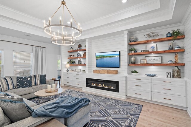 24 Palmer Ln, Santa Rosa Beach, FL 32459 - living room featuring a tray ceiling, a chandelier, visible vents, light wood-style flooring, and a glass covered fireplace