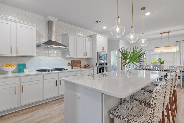 24 Palmer Ln, Santa Rosa Beach, FL 32459 - kitchen featuring ornamental molding, a breakfast bar, backsplash, wall chimney range hood, and appliances with stainless steel finishes