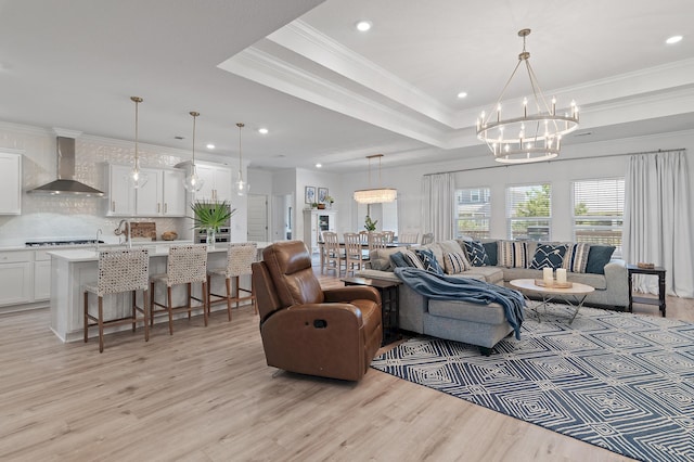 24 Palmer Ln, Santa Rosa Beach, FL 32459 - living room with ornamental molding, light wood-style floors, a notable chandelier, and a raised ceiling