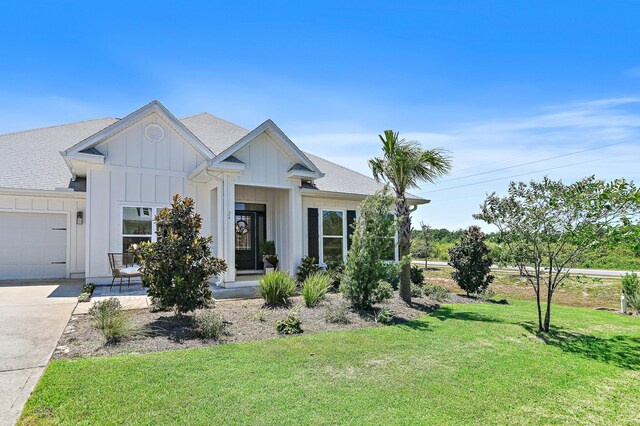 24 Palmer Ln, Santa Rosa Beach, FL 32459 - view of front of house with an attached garage, a front lawn, board and batten siding, roof with shingles, and driveway