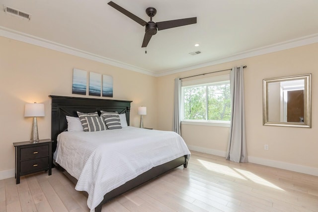 bedroom with light wood-style flooring, crown molding, baseboards, and visible vents