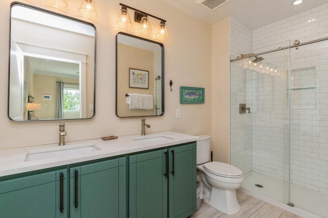 full bath with a shower stall, visible vents, toilet, and a sink