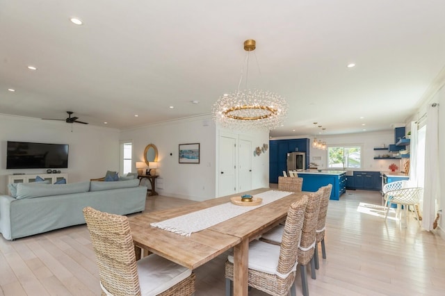 dining room with crown molding, light wood finished floors, baseboards, recessed lighting, and ceiling fan with notable chandelier