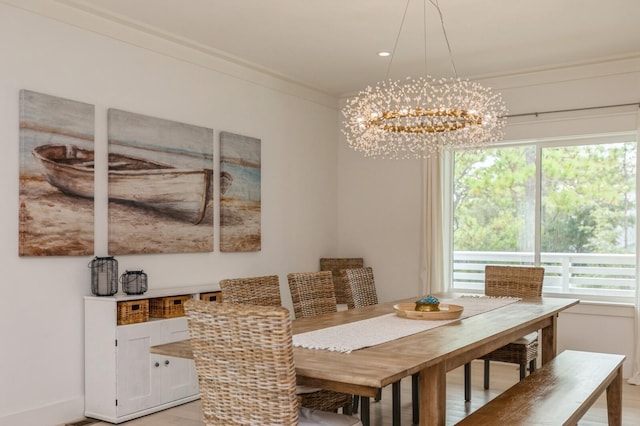 dining room featuring ornamental molding, an inviting chandelier, and light wood-type flooring