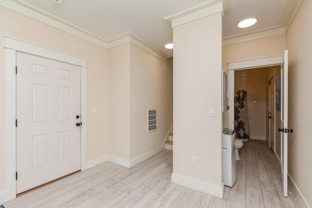 entryway with baseboards, stairs, ornamental molding, and light wood finished floors