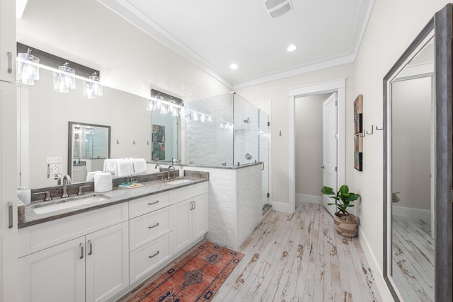 full bath featuring a sink, visible vents, a stall shower, and crown molding