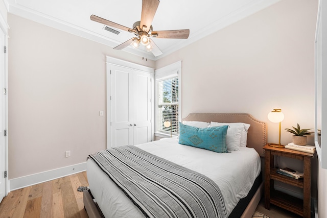 bedroom with a closet, baseboards, a ceiling fan, visible vents, and light wood finished floors