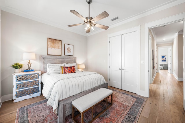 bedroom with ornamental molding, visible vents, baseboards, and wood-type flooring