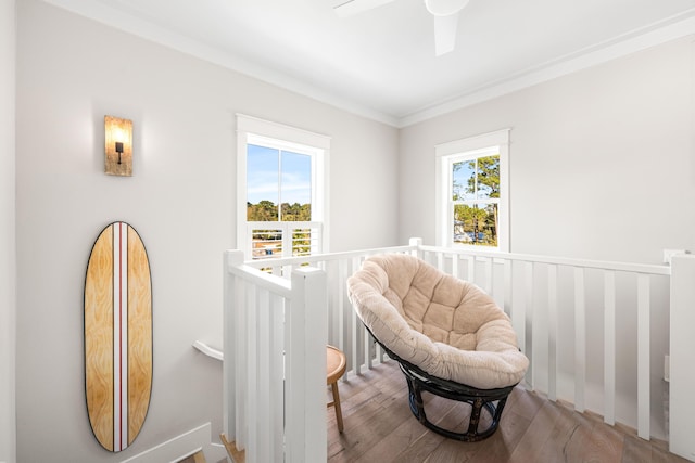 living area featuring crown molding, an upstairs landing, wood finished floors, and a ceiling fan