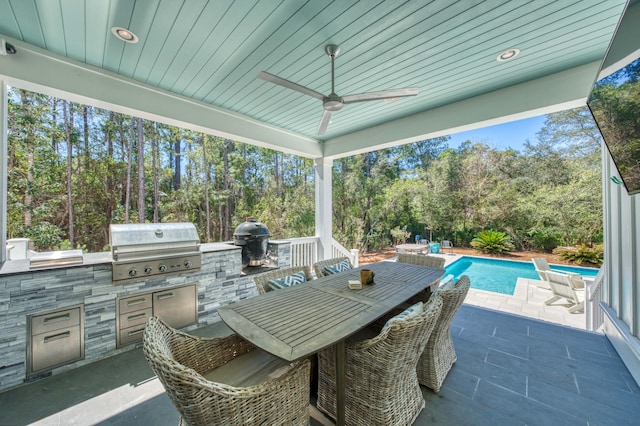 view of patio featuring exterior kitchen, an outdoor pool, a grill, and ceiling fan
