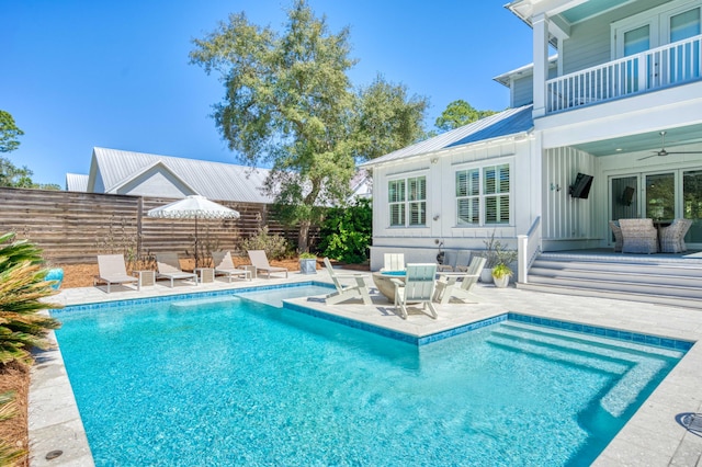 view of pool with ceiling fan, a patio area, a fenced in pool, and fence