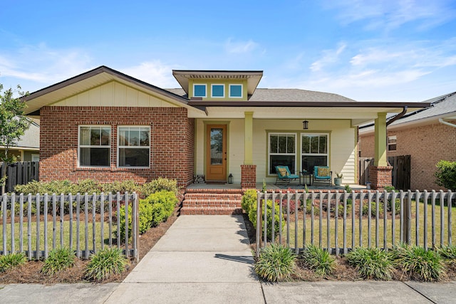 bungalow featuring fence private yard, a porch, and brick siding
