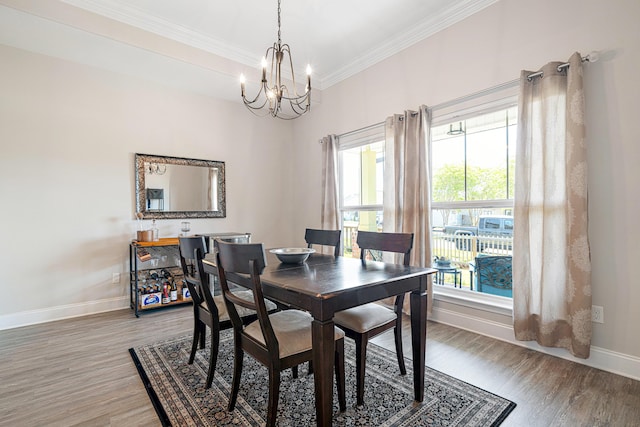 dining space with baseboards, ornamental molding, a notable chandelier, and light wood-type flooring