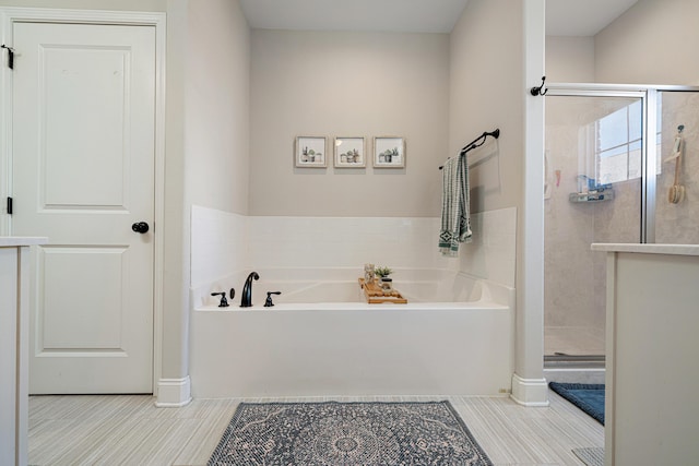 bathroom featuring tile patterned flooring, a garden tub, and a stall shower