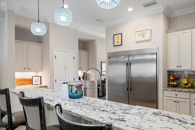 kitchen with visible vents, crown molding, backsplash, and stainless steel built in refrigerator