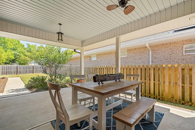 view of patio featuring outdoor dining area, a fenced backyard, and a ceiling fan