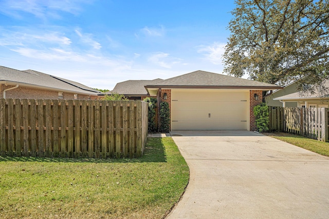 view of front of property featuring fence, an attached garage, brick siding, a front yard, and driveway