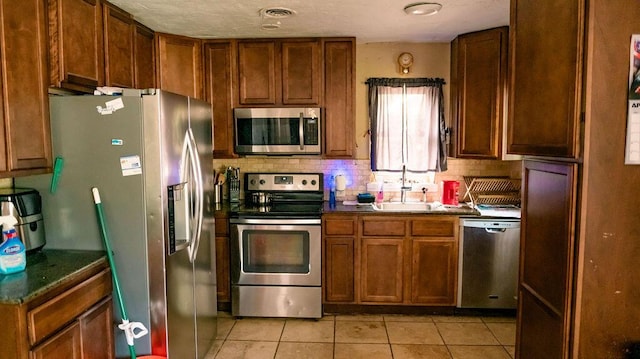 306 N 58th Ave, Pensacola, FL 32506 - kitchen with a sink, visible vents, light tile patterned floors, dark countertops, and appliances with stainless steel finishes