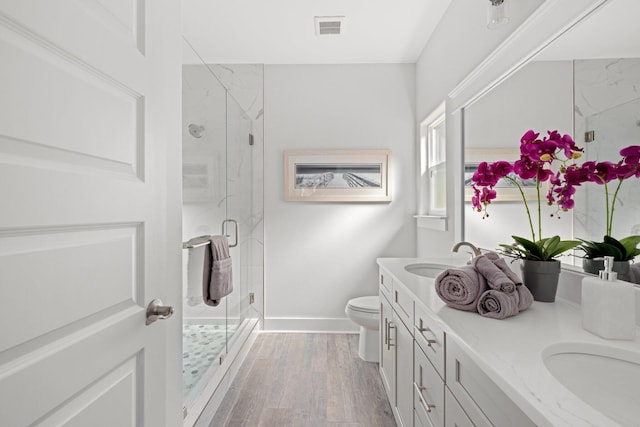 213 N Wells St, Panama City Beach, FL 32413 - full bath featuring toilet, a sink, visible vents, double vanity, and wood finished floors