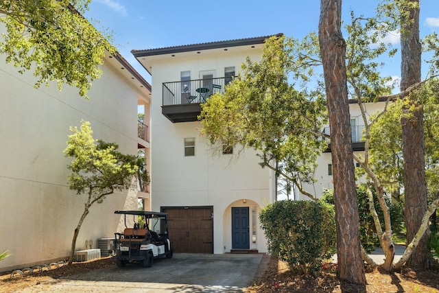 10 Mar A Lago Blvd # 14, Santa Rosa Beach, FL 32459 - back of house with a garage, central AC, a balcony, stucco siding, and concrete driveway