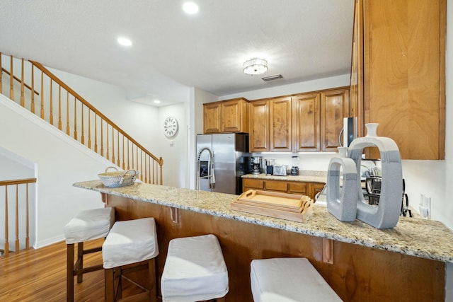 10 Mar A Lago Blvd # 14, Santa Rosa Beach, FL 32459 - kitchen featuring brown cabinetry, light wood finished floors, light stone countertops, and stainless steel fridge with ice dispenser