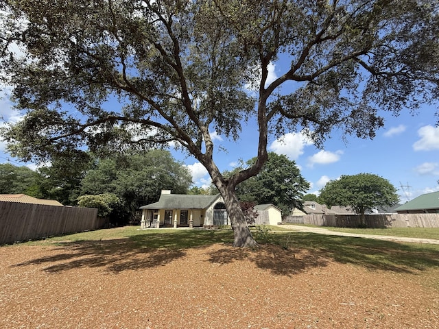 obstructed view of property featuring fence, a chimney, and a front yard