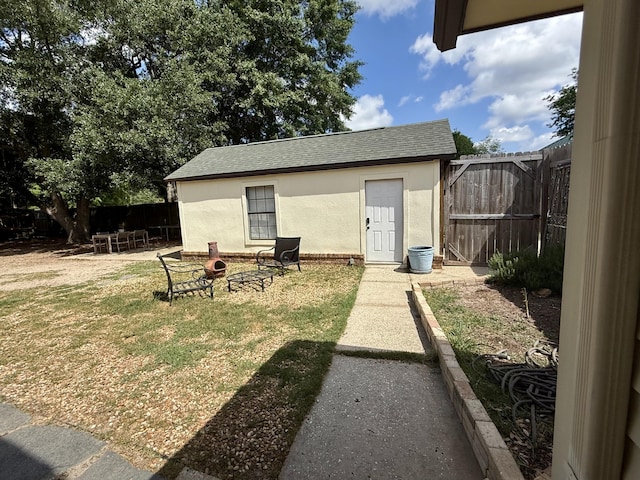 view of outbuilding featuring fence and an outdoor structure