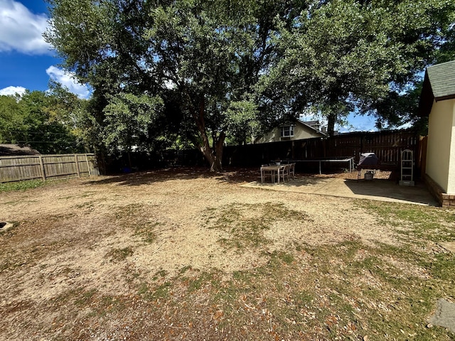 view of yard with a trampoline and a fenced backyard