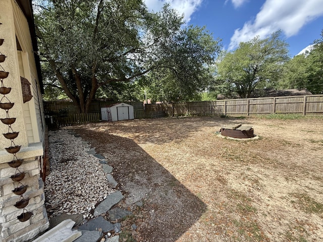 view of yard with a storage unit, a fenced backyard, and an outdoor structure