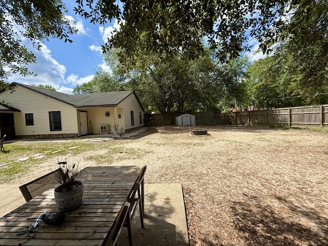 view of yard with a fenced backyard, a shed, and an outdoor structure