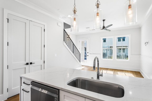 kitchen featuring stainless steel dishwasher, a ceiling fan, white cabinets, wood finished floors, and a sink