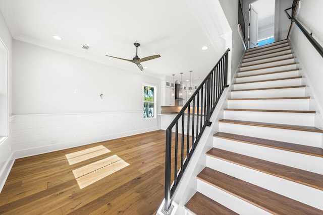 stairs with recessed lighting, a wainscoted wall, visible vents, ceiling fan, and hardwood / wood-style flooring