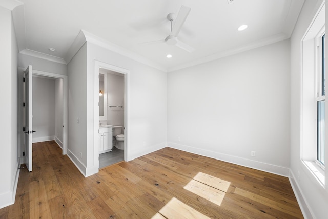 unfurnished bedroom featuring light wood-style flooring, baseboards, and crown molding