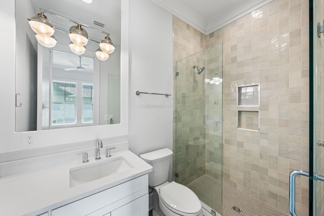 bathroom featuring toilet, a shower stall, and vanity