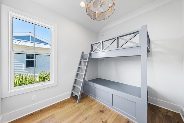 bedroom featuring light wood finished floors, multiple windows, and baseboards