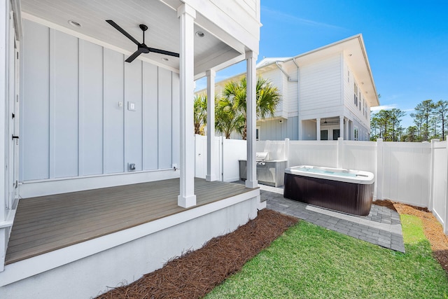 exterior space with a fenced backyard, a hot tub, and ceiling fan