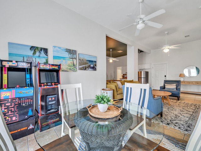 tiled dining room featuring lofted ceiling, a ceiling fan, and visible vents