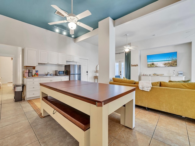 kitchen featuring a ceiling fan, appliances with stainless steel finishes, white cabinetry, and light tile patterned floors