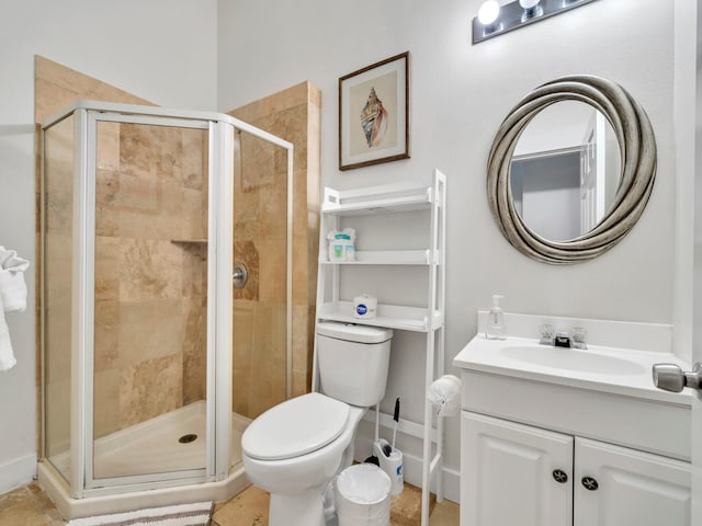 bathroom with a shower stall, toilet, and vanity
