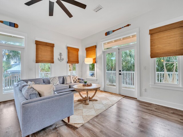 living room featuring wood finished floors, visible vents, french doors, baseboards, and ceiling fan