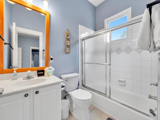 bathroom featuring vanity, tile patterned flooring, shower / bath combination with glass door, and toilet