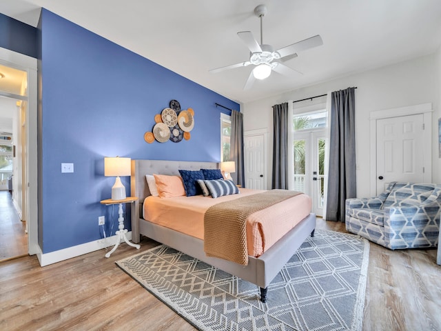 bedroom with baseboards, a ceiling fan, wood finished floors, and access to exterior