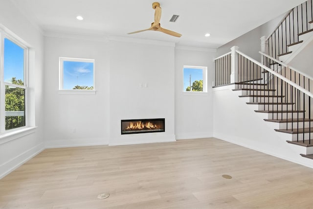162 Casting Lake Rd, Miramar Beach, FL 32550 - unfurnished living room with a glass covered fireplace, plenty of natural light, stairway, ornamental molding, and recessed lighting