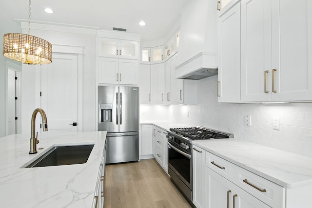 162 Casting Lake Rd, Miramar Beach, FL 32550 - kitchen featuring stainless steel appliances, premium range hood, a chandelier, decorative backsplash, and light wood-style flooring