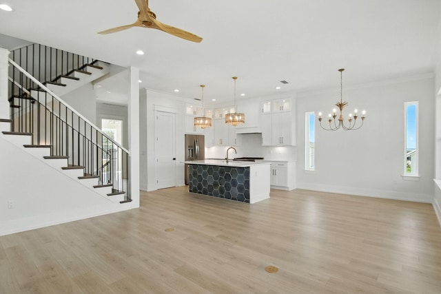 162 Casting Lake Rd, Miramar Beach, FL 32550 - unfurnished living room featuring a chandelier, a ceiling fan, stairway, ornamental molding, and light wood-style flooring