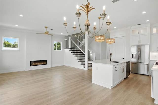 162 Casting Lake Rd, Miramar Beach, FL 32550 - kitchen with appliances with stainless steel finishes, light countertops, recessed lighting, an island with sink, and a glass covered fireplace