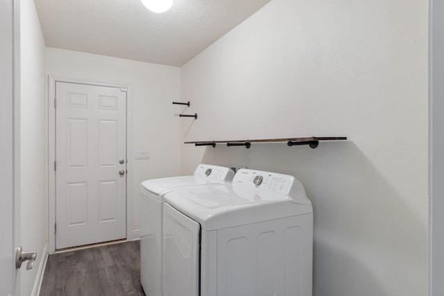 laundry room featuring a textured ceiling, dark wood-style floors, laundry area, and washer and clothes dryer