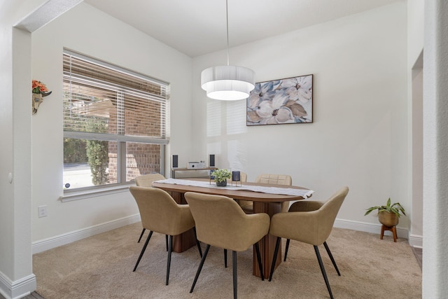 dining room with light carpet and baseboards