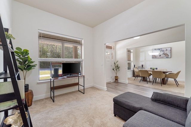 carpeted living room with baseboards